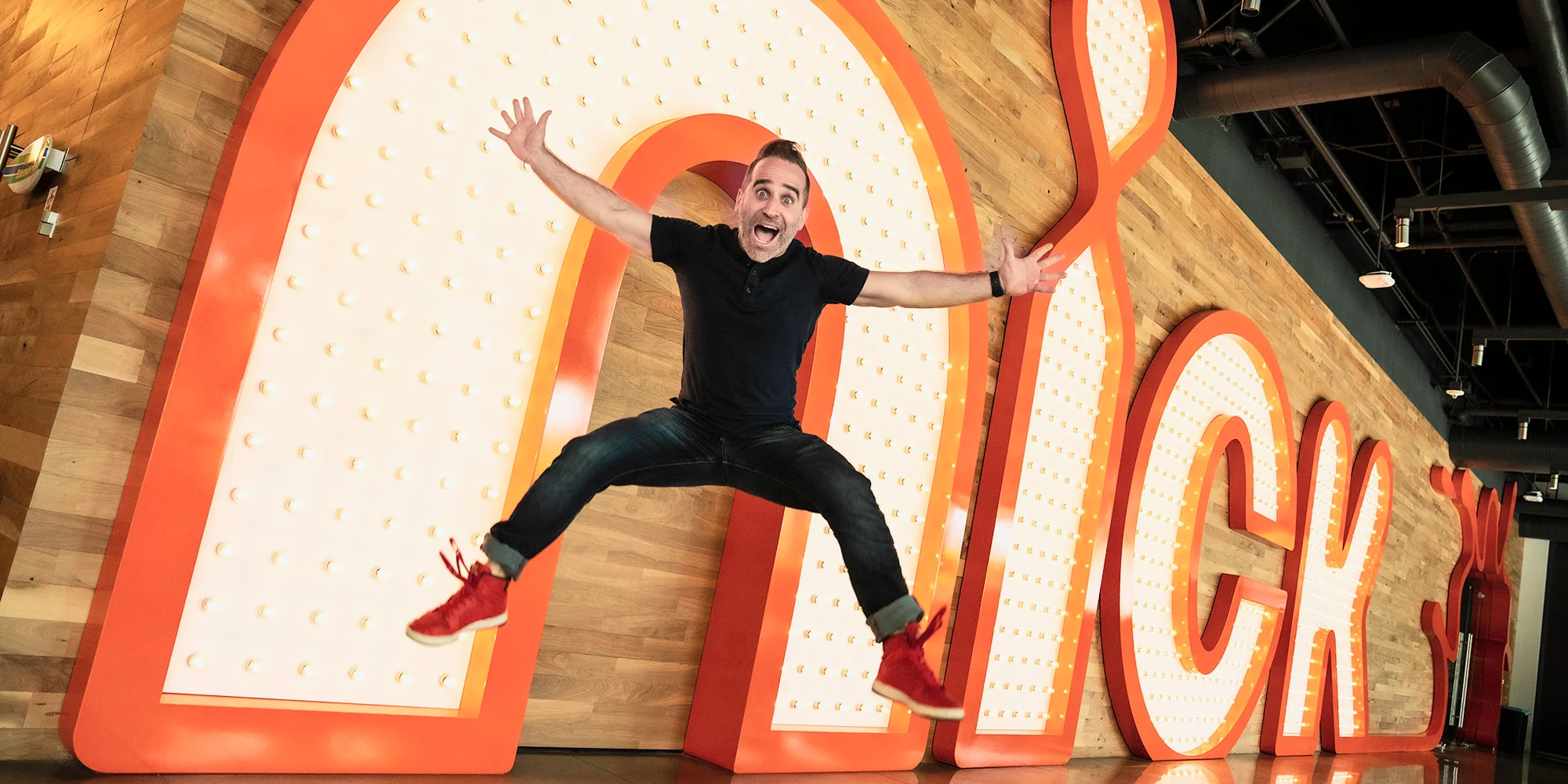 Ben leaping in front of the giant Nick sign.